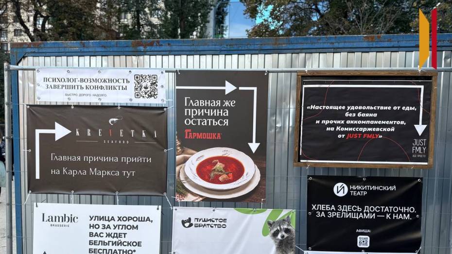 На заборе стройки в центре Воронежа устроили рекламный баттл