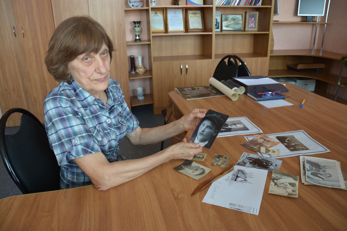 Наталья Суханова рассматривает фотографию отца, сделанную в 1938 году, тогда он только окончил медучилище в Красном Луче